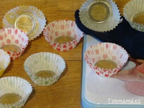 Pegamos las monedas a la base del molde de papel con cinta de doble cara.