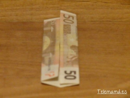 Doblamos los dos extremos hacia el centro del billete.